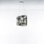 Artemide Logico suspension lamp with a transparent blown glass shade in the signature pinched and folded sculptural form, three quarter view.