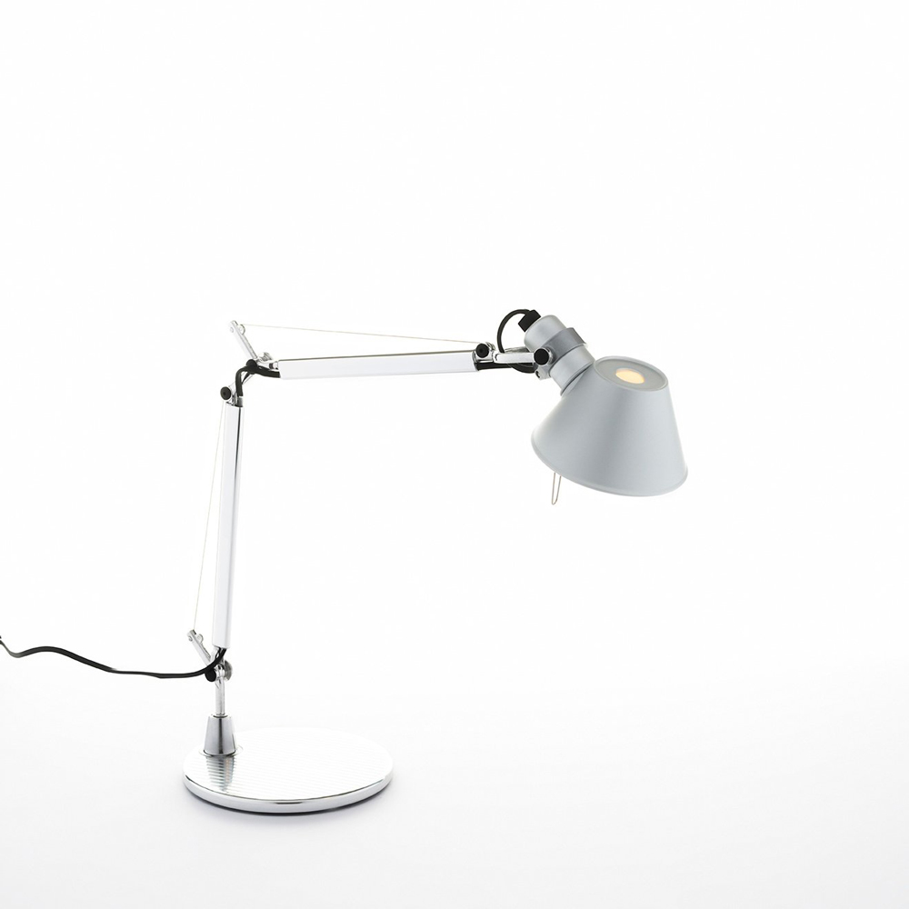Artemide Tolomeo Micro table lamp in polished aluminum, micro scale articulated arm and conical shade on a small base, three quarter view.