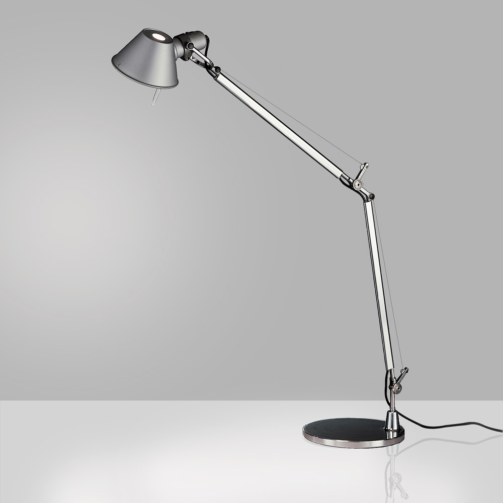 Artemide Tolomeo Classic table lamp in polished aluminum, articulated counterweight arm with a conical metal shade on a weighted circular tabletop base, three quarter view.