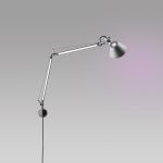 Artemide Tolomeo Wall lamp in polished aluminum, articulated arm with conical shade extending from a small circular wall plate, three quarter view.