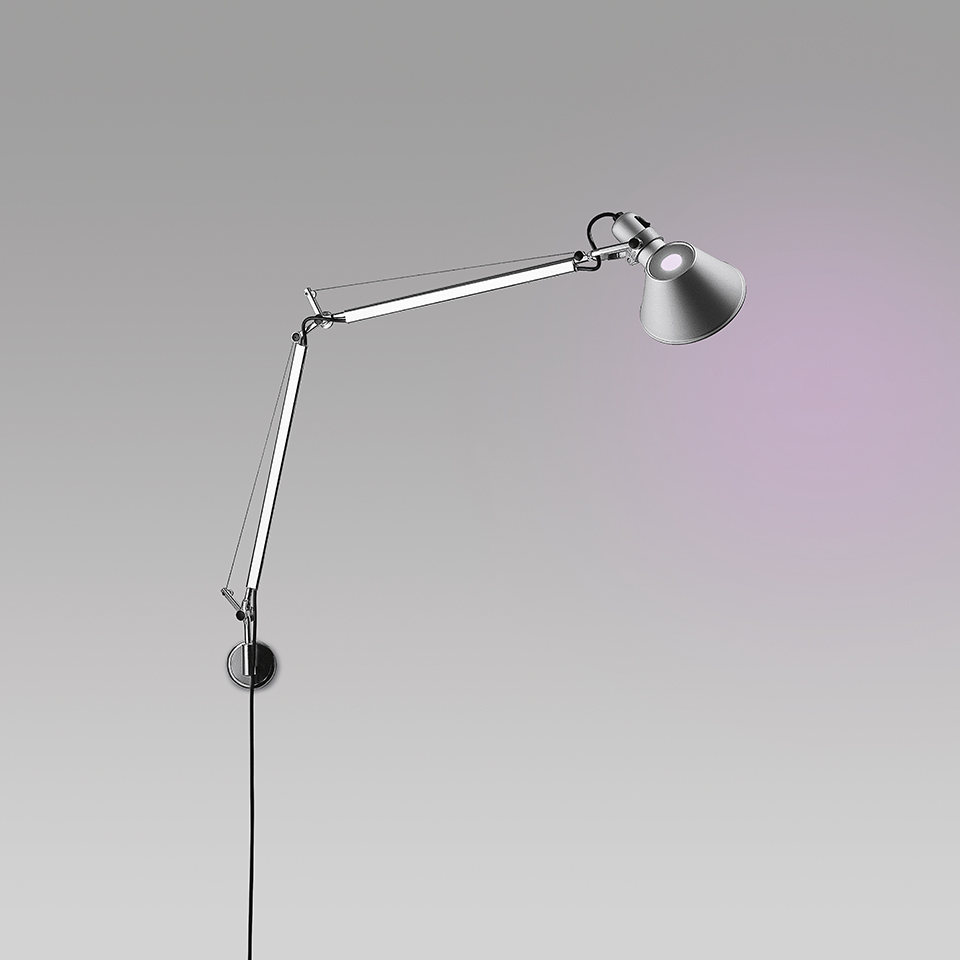 Artemide Tolomeo Wall lamp in polished aluminum, articulated arm with conical shade extending from a small circular wall plate, three quarter view.